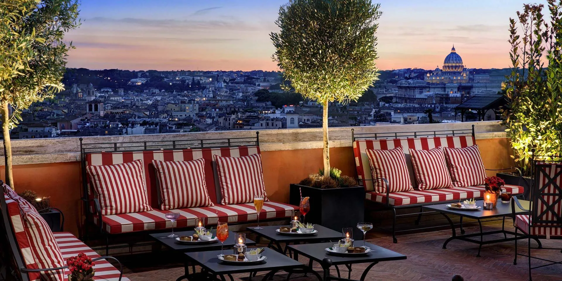 A rooftop terrace overlooking the roofs of Rome at dusk